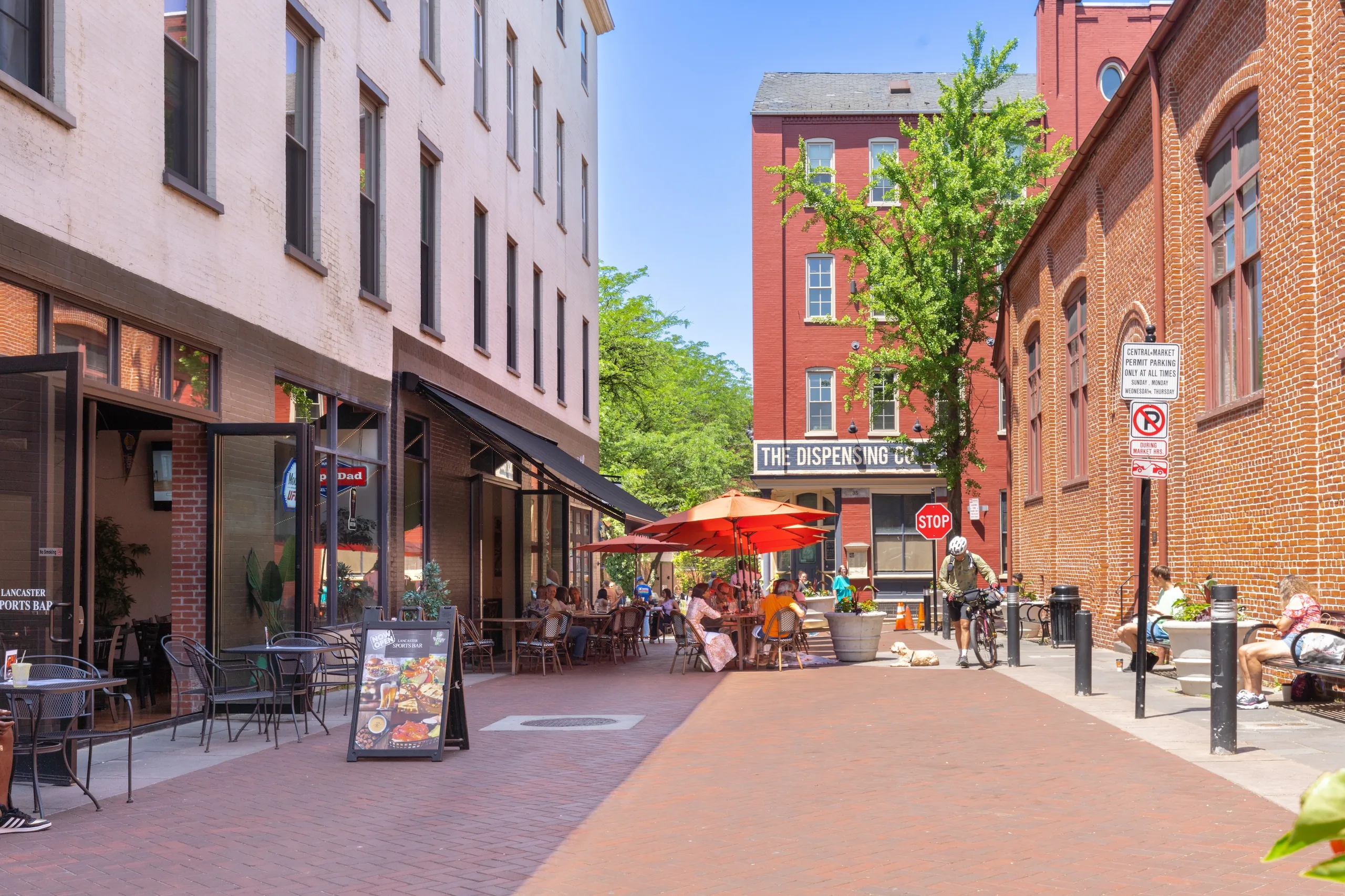 Outdoor dining and pedestrians among historic brick buildings in downtown Lancaster