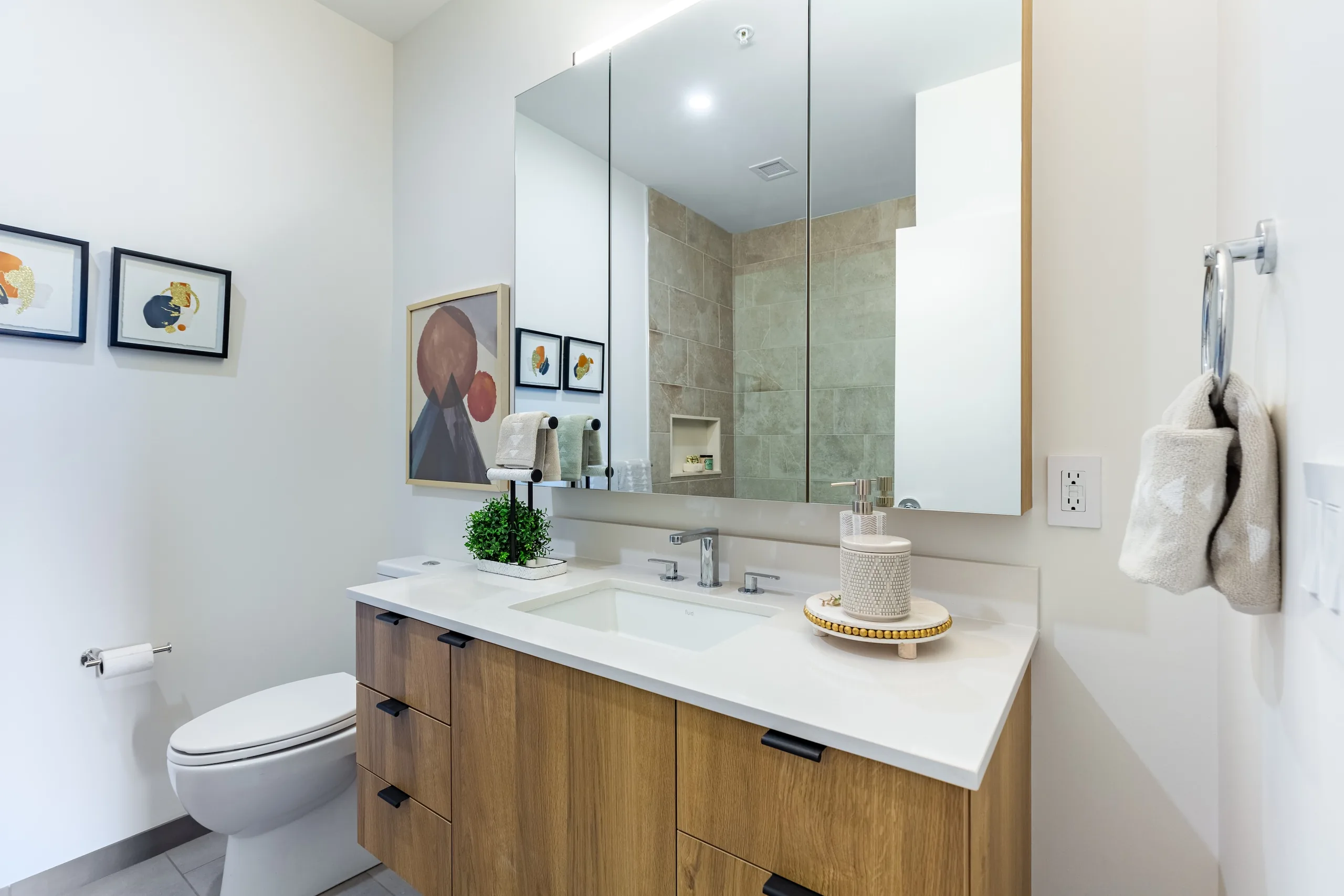 Angled bathroom view with oak vanity, mirror and shower