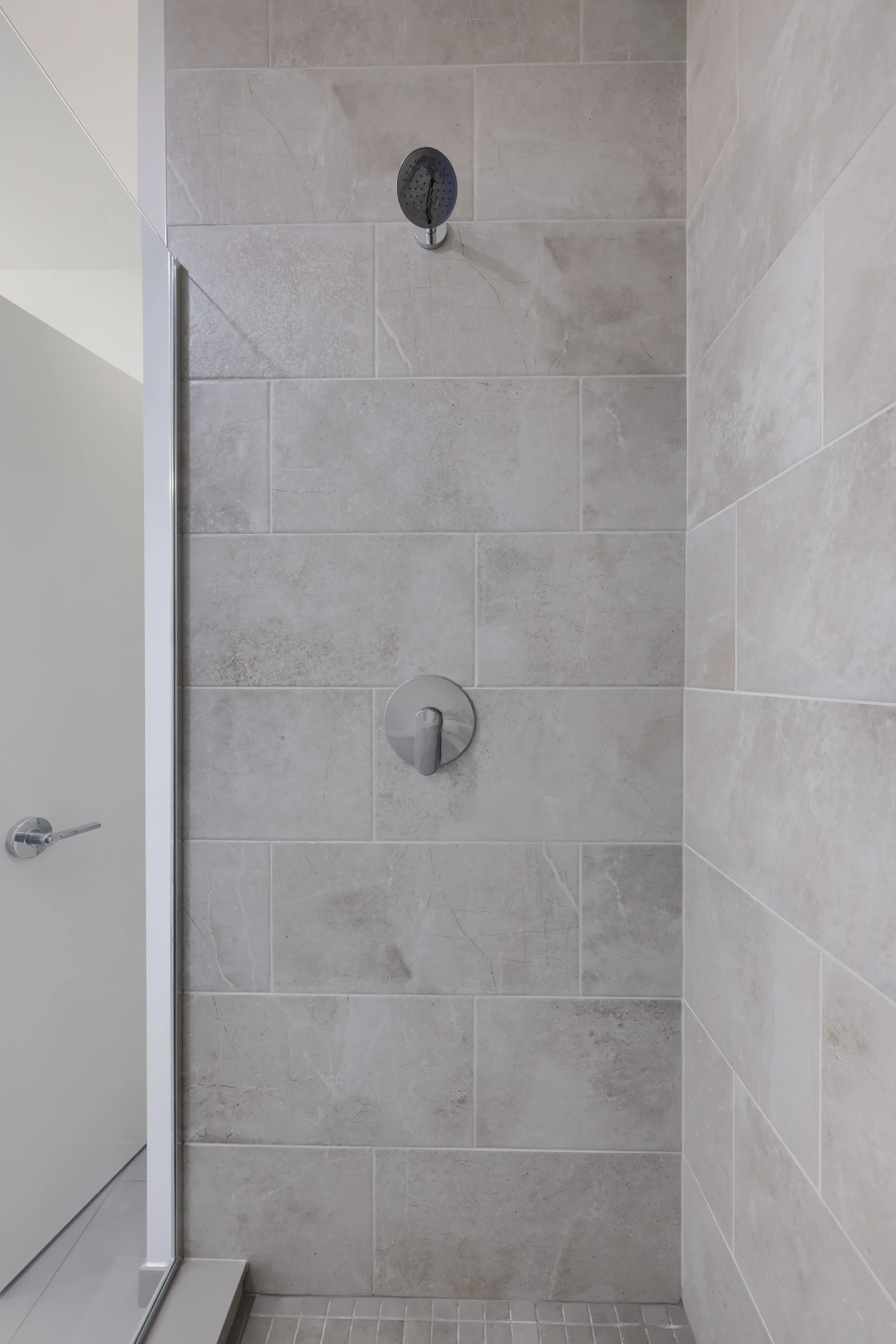 Tiled shower with dark fixtures and a recessed niche