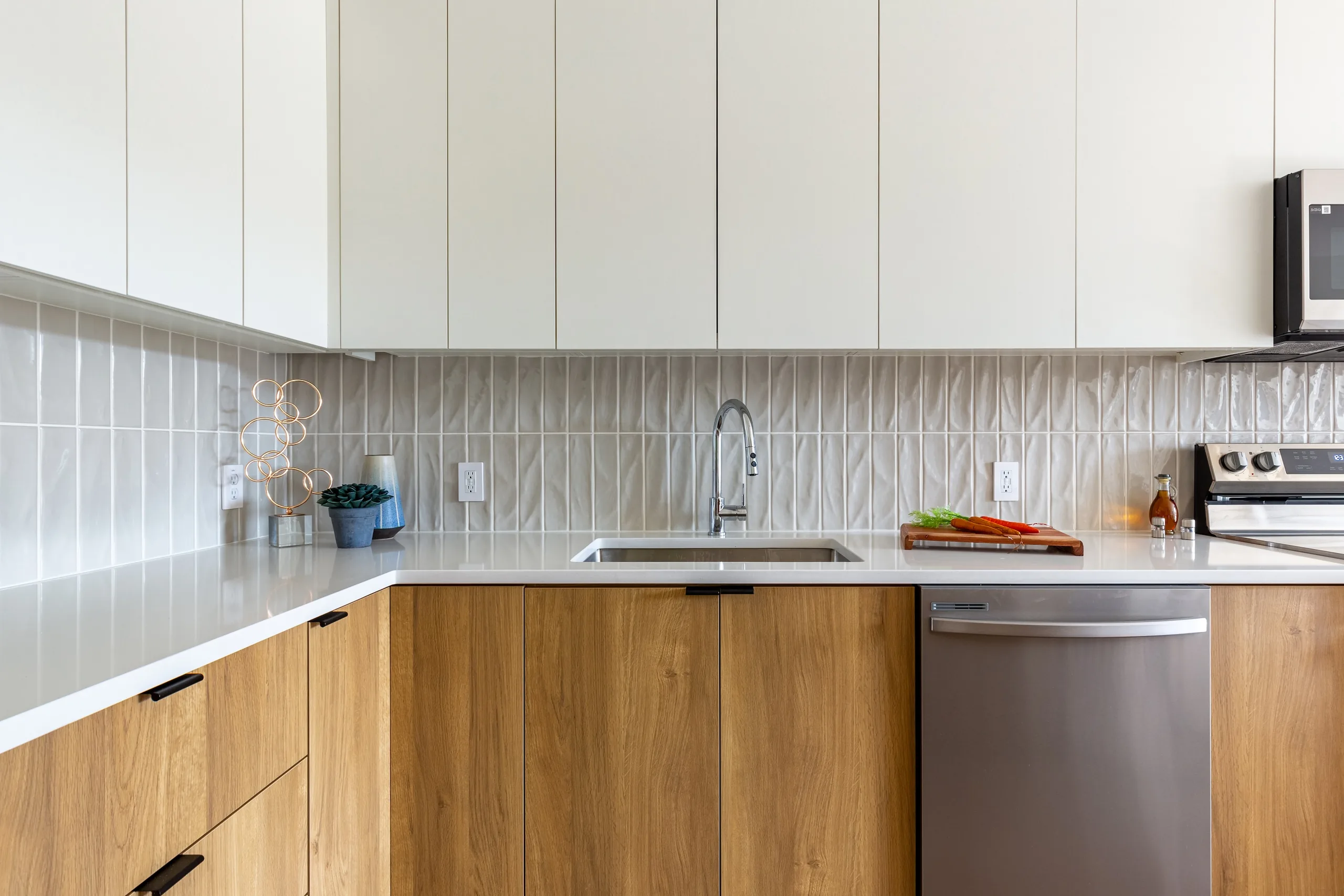 Two-tone kitchen with quartz counters at The Alistair Apartments