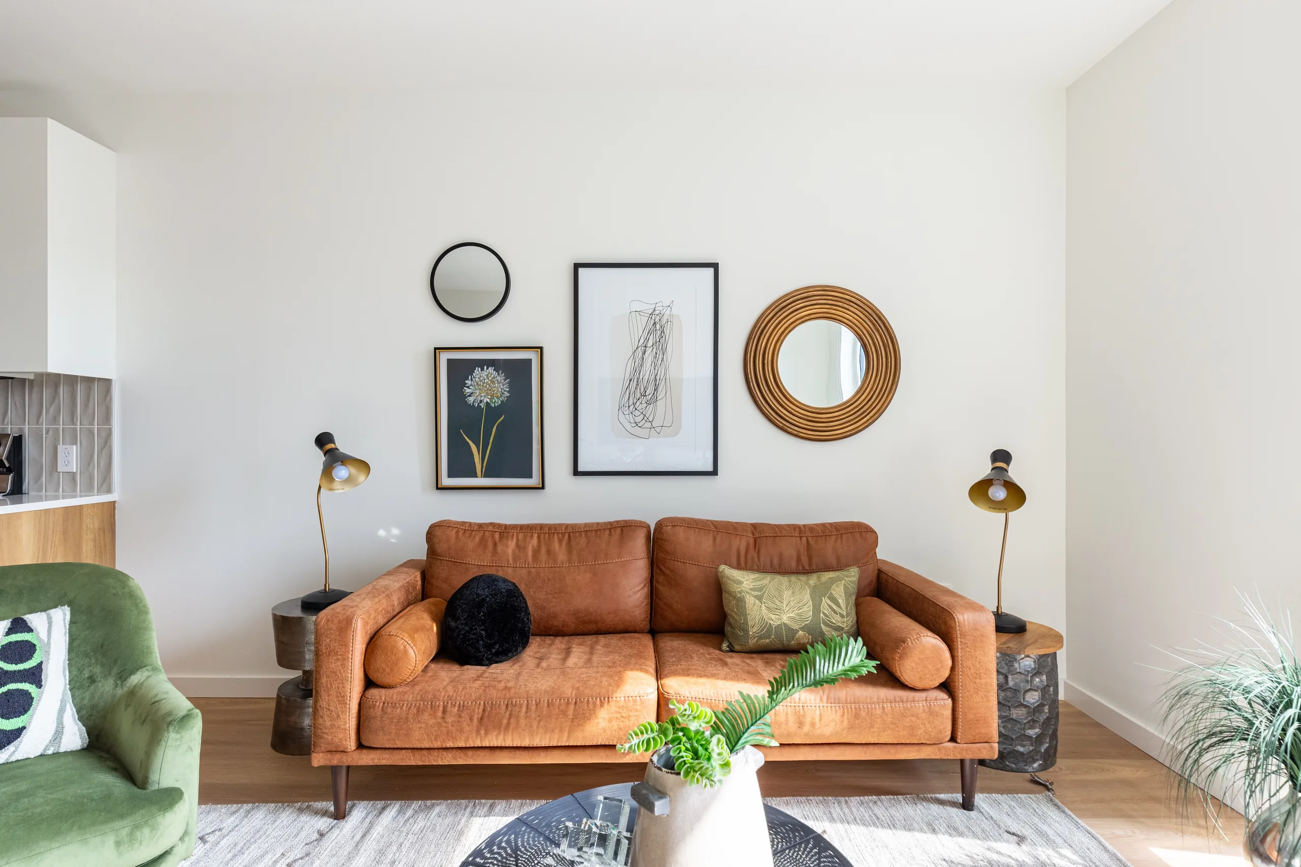Staged model living room with a warm sofa and layered wall art